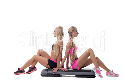 Shaping. Pretty blondes posing sitting on stepper