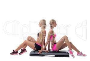 Shaping. Pretty blondes posing sitting on stepper