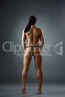 Rear view of female bodybuilder posing topless