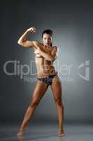 Studio photo of muscular woman showing biceps