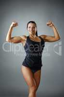 Happy female bodybuilder showing her biceps