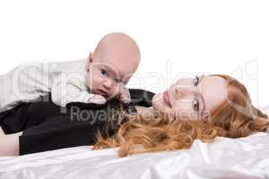 Lovely red-haired woman with baby on chest