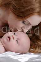 Portrait of mother kisses her adorable little son