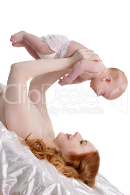 Happy red-haired mother hold baby over her head