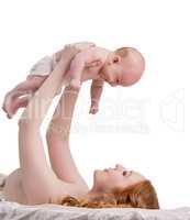 Pretty red-haired mother playing with her baby