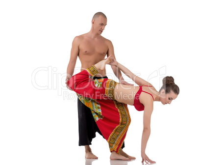 Yoga instructor helps girl to perform asana