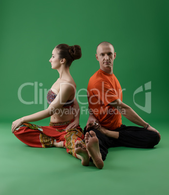 Man and woman doing yoga in pair. Studio photo