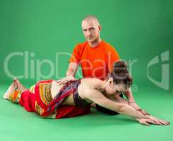 Yoga. Instructor helps woman to perform asana