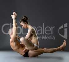 Studio photo of topless partners exercising yoga