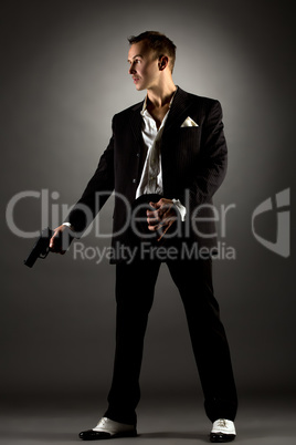 Handsome man dressed as gangster holding gun