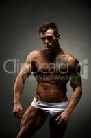 Bodybuilder advertises underwear. Studio photo