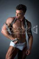 Hot muscular guy wrapped his biceps with chain
