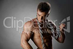 Portrait of tanned bodybuilder posing with chain