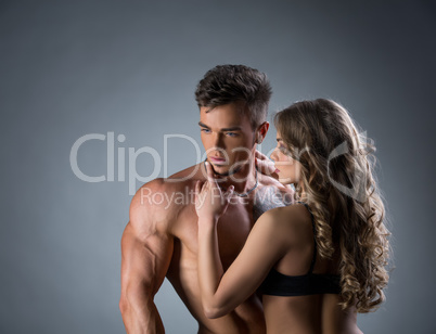 Curly girl hugging handsome bodybuilder