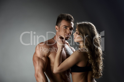 Loving woman admires sexy tanned bodybuilder