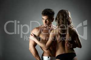 Studio photo of bodybuilder hugs topless model