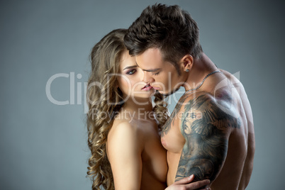 Charming model lovingly looks at tattooed man