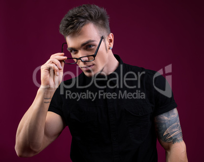 Portrait of sexy bodybuilder took off his glasses