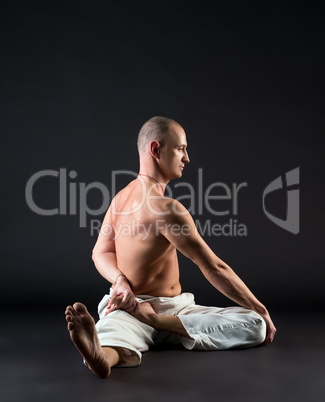 Studio image of middle-aged man doing yoga pose