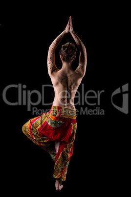 Rear view of slender topless woman practicing yoga