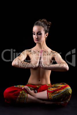 Mehendi. Pretty woman meditating in lotus position
