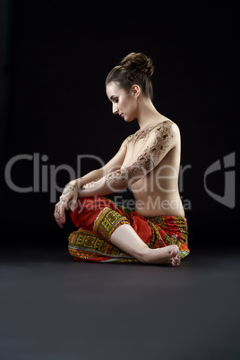 Photo of topless woman with henna patterns on body