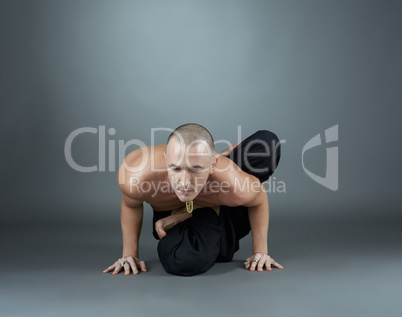 Yogi performs asana. Studio shot, on gray backdrop