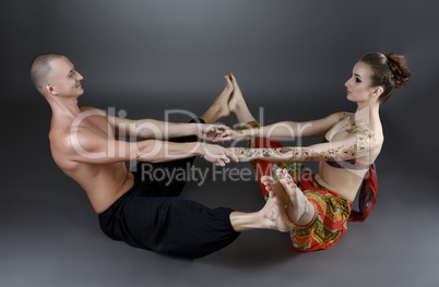 Yoga with partner. Trainers show one of asanas