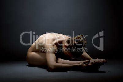 Naked model in pose of stretching. Studio photo