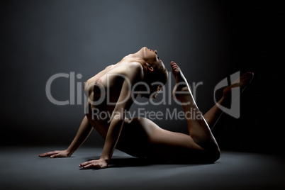 Aerobics. Flexible girl posing nude in studio