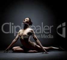 Beautiful female dancer posing nude at camera