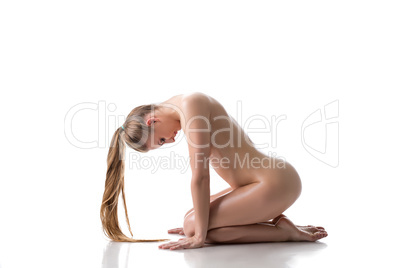 Nude pretty woman posing with her head bowed