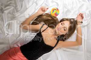 Top view of sexy young coquette with lollipop