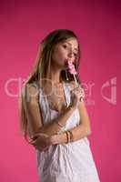 Flirtatious girl in nightie kissing lollipop