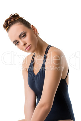 Attractive young dancer posing with her head bowed