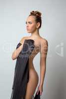 Nude model posing covered her body with fabric