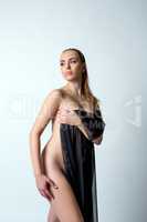Pretty woman hides her nakedness with black cloth