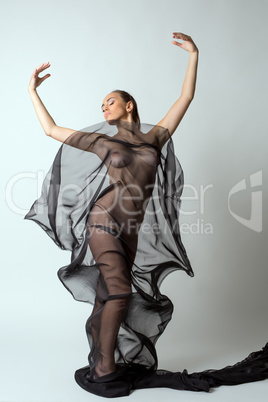 Woman gracefully dancing with transparent cloth