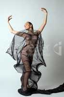 Woman gracefully dancing with transparent cloth