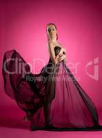 Elegant nude model posing with flying fabric