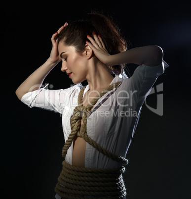 Shibari. Studio image of sexy woman tied with rope