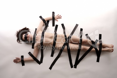 BDSM. Blindfolded nude woman tied with duct tape