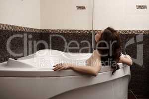 Image of nude brunette enjoys taking bath