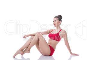 Pretty gymnast sitting, pulling her knees to chest
