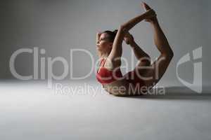 Beautiful gymnast in complex stretching posture