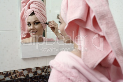 Image of smiling flirtatious woman using mascara