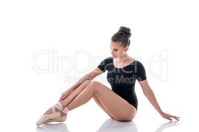 Ballerina looking at her slender legs in pointes