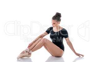Ballerina looking at her slender legs in pointes