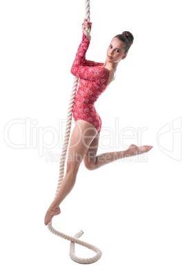 Gymnast looking at camera while hanging on rope