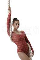 Gymnast in beautiful red leotard posing with rope